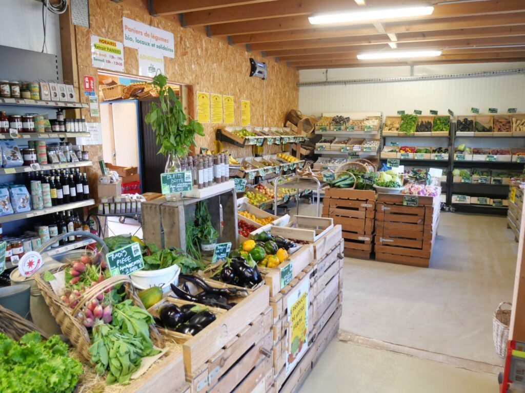 Boutique de la Ferme des Potagers de Marcoussis : étals de légumes bio, bocaux de la conserverie et paniers