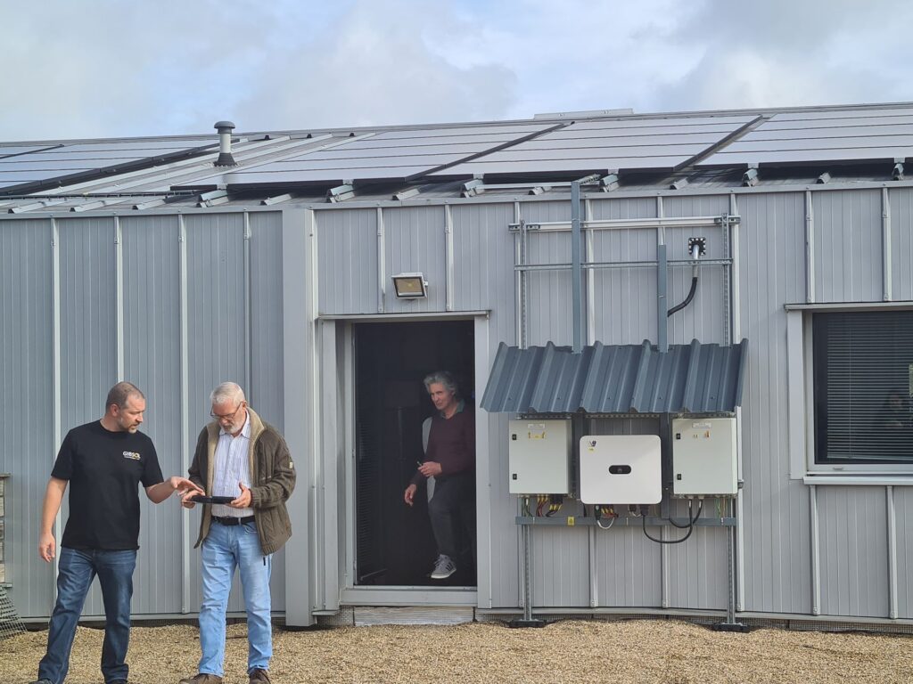 Panneaux solaires et onduleurs sur le toit de la Ferme des Potagers de Marcoussis, présentés par l’installateur lors de la visite
